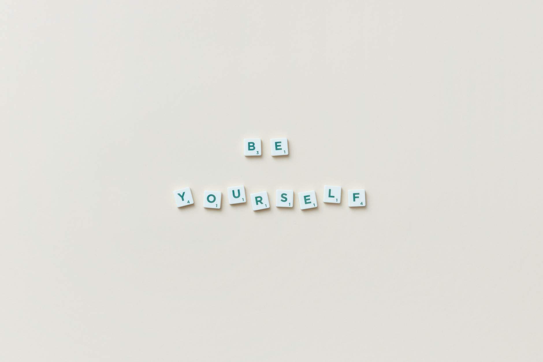 Motivational phrase "Be Yourself" spelled with letter tiles on a white background.