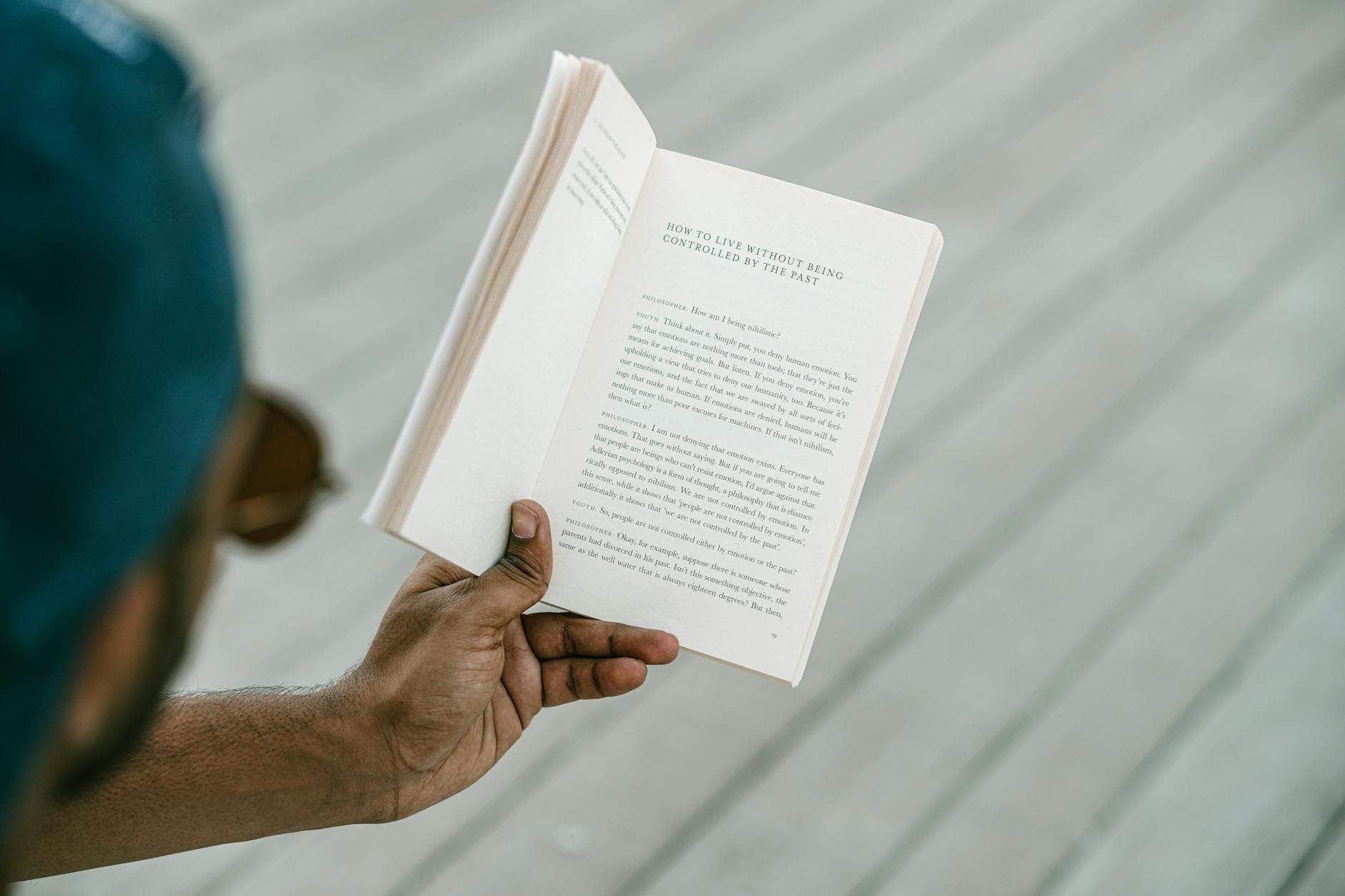 A person engrossed in reading an inspirational book outdoors on a sunny day.