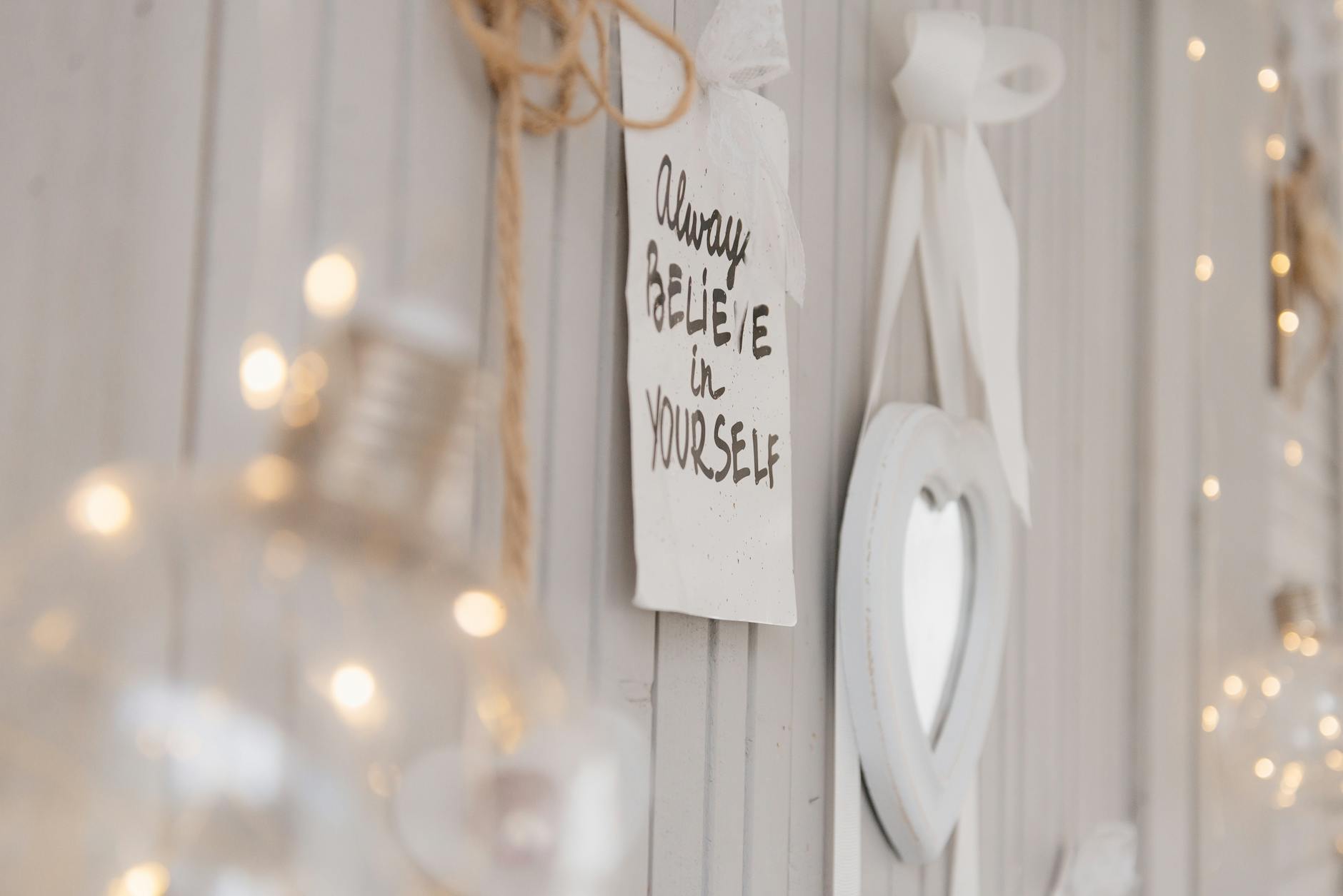 Close-up of a motivational quote on a wall with soft lighting and decor.