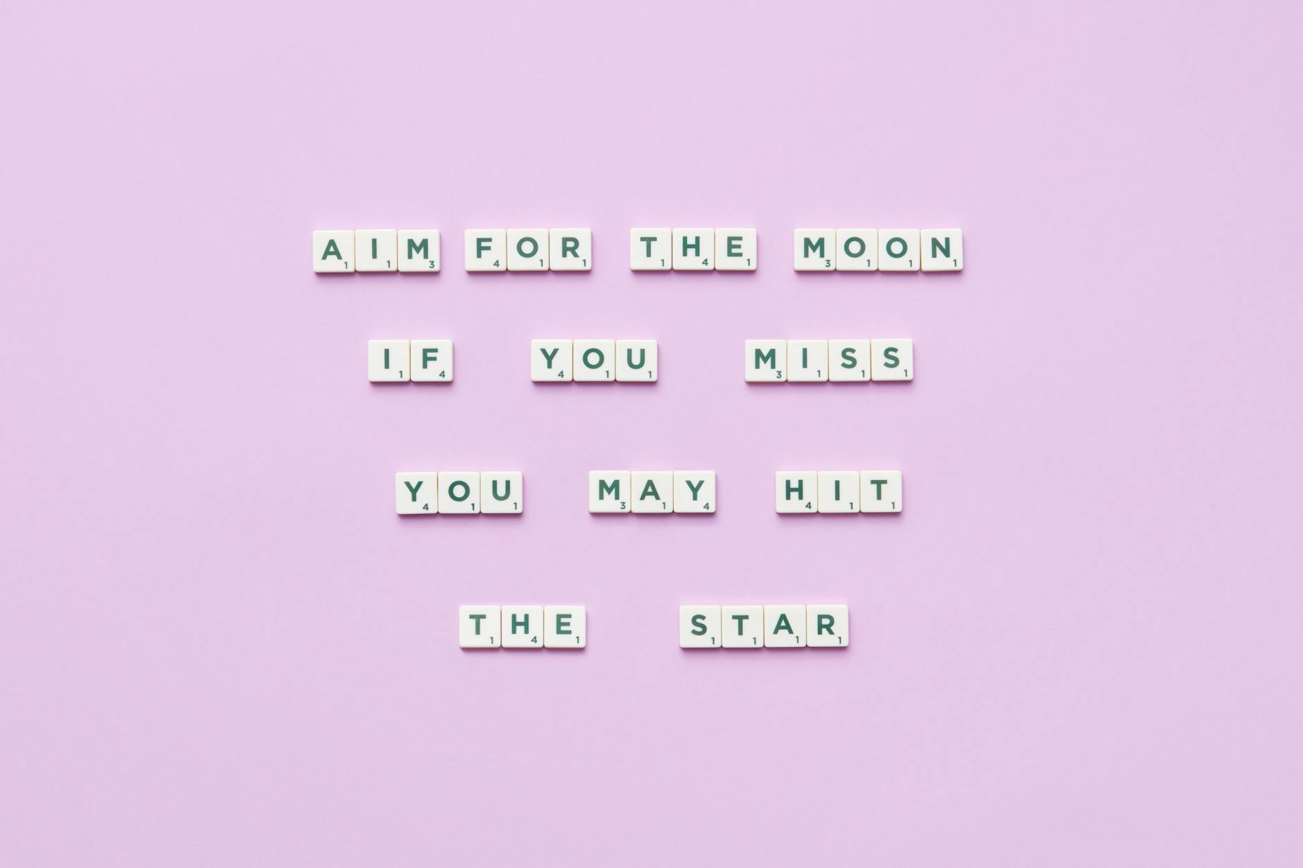 Inspirational message using Scrabble tiles on a pastel background.