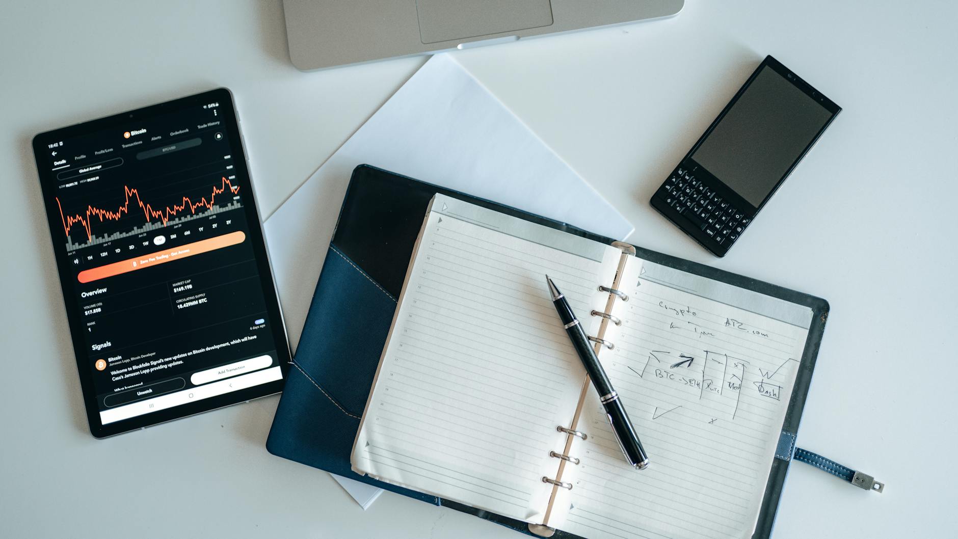 Business setup showcasing a digital tablet, notebook, and smartphone with financial data.