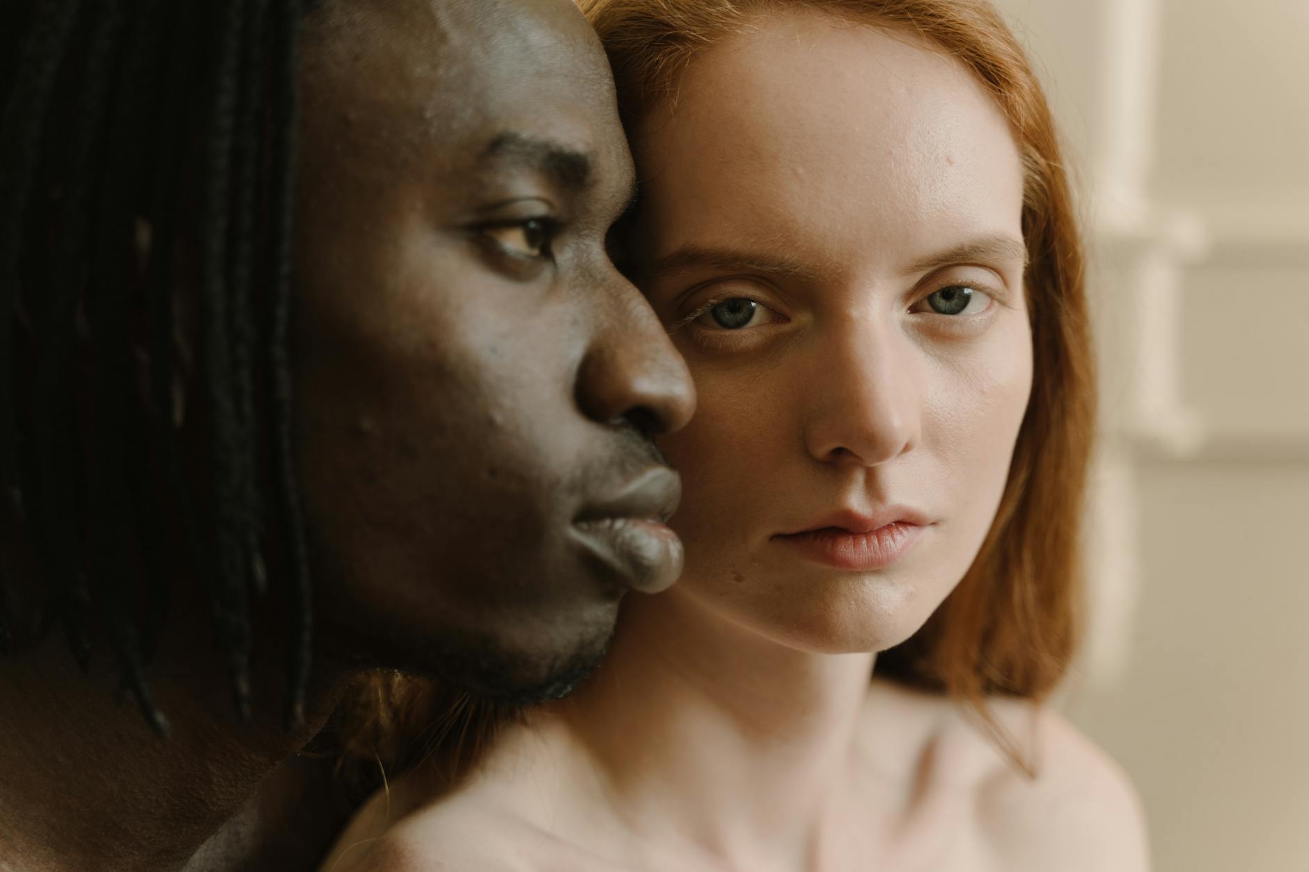 A close-up portrait of a loving interracial couple, depicting tenderness and connection.